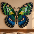 A large decorative butterfly wall art piece in vivid green, blue, and black hangs above a bed in a warmly lit bedroom.
